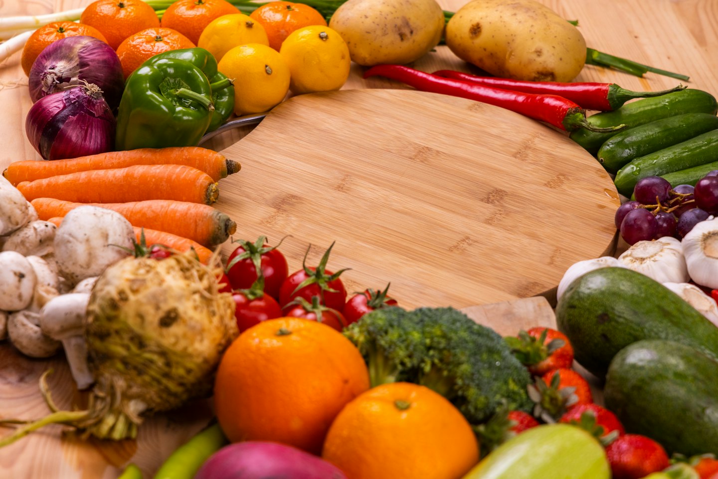 Frutta e verdura fresca disposte su un tagliere di legno.